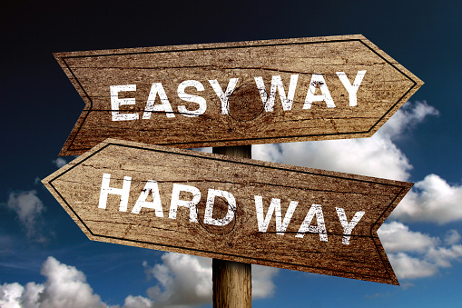 Easy Way And Hard Way concept road sign with blue sky background.