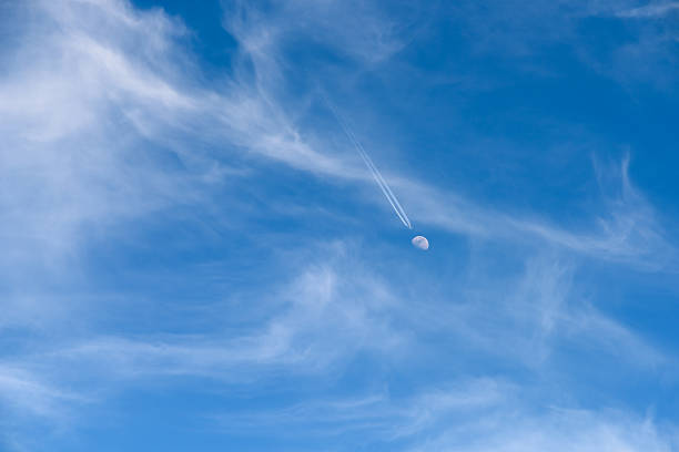 Airplane Flying To The Moon Concept On Blue Sky With Clouds