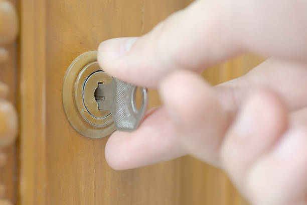istock Closeup of male hand unlocking cabinet 528636019