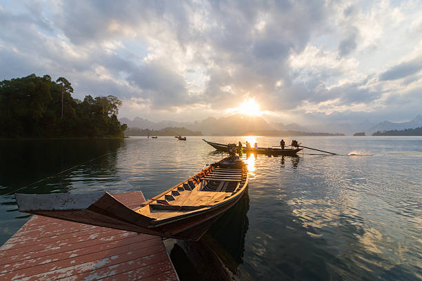 istock boat at sunrise in Ratchaprapa Dam 528636592