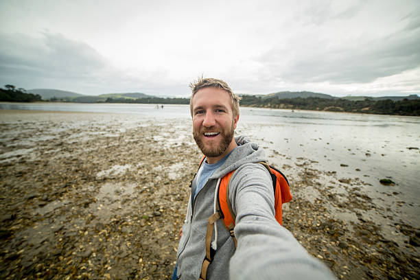 istock Cheerful young man takes a selfie portrait on a beach 528637040