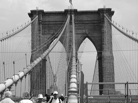 New York City, NY, USA - June 24, 2002: Pedestrians cross the Brooklyn Bridge in NYC.