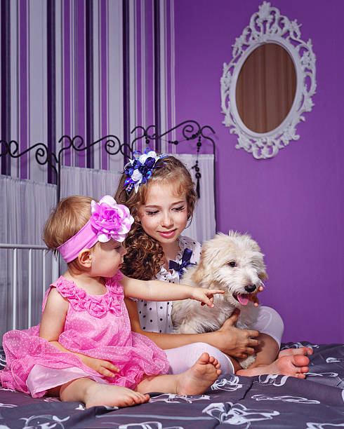 istock Little sisters and puppy 528678583