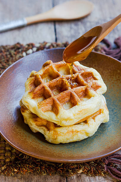 istock Honey pouring on a fresh waffles. 528679099