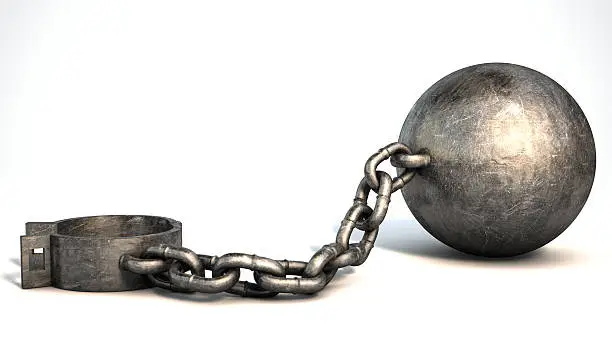 A vintage ball and chain with an open shackle on an isolated white studio background