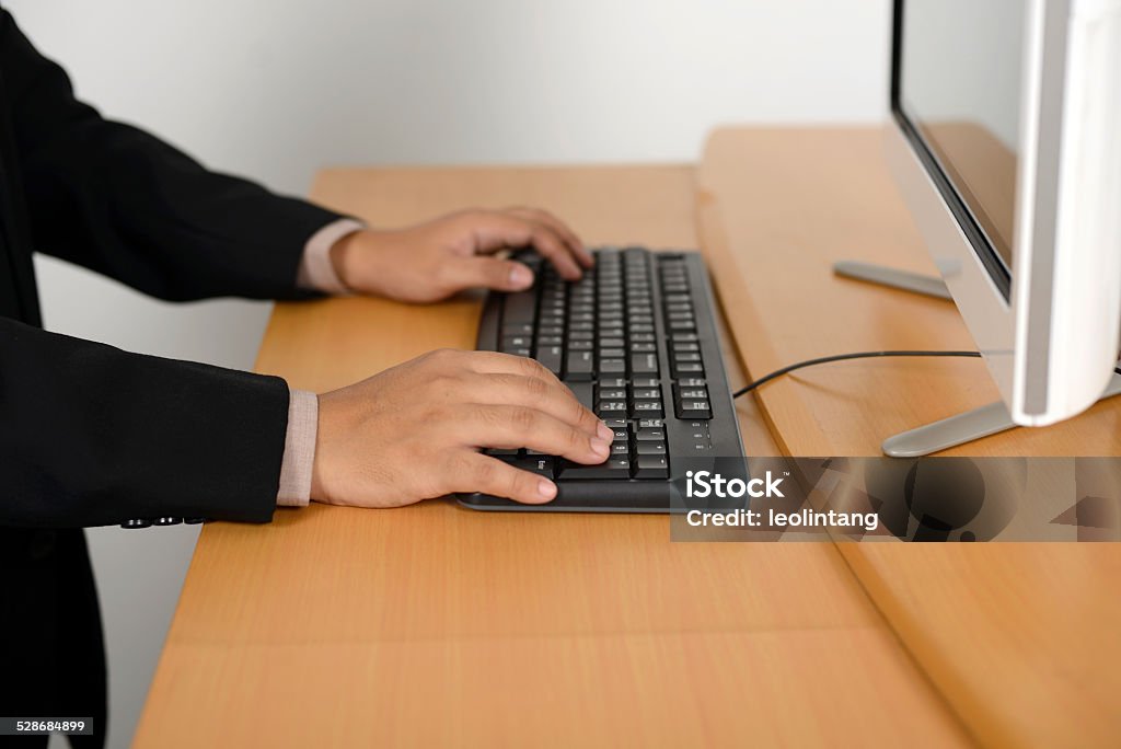 Business man typing with keyboard Business man typing with keyboard on wooden desk Adult Stock Photo