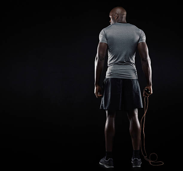 muscolare uomo in piedi con saltare la corda - human muscle back muscular build men foto e immagini stock