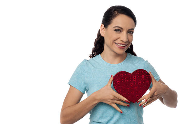 istock Smiling woman with heart shape gift box 528685327