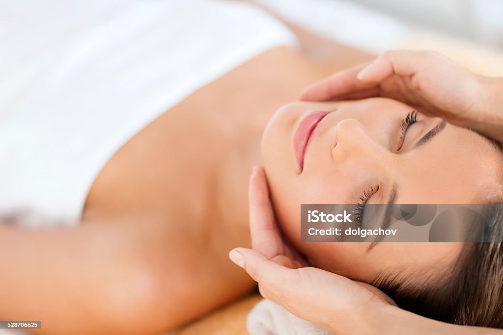 beautiful woman in spa salon health, beauty, people and relaxation concept - beautiful woman in spa salon getting face treatment Facial Mask - Beauty Product Stock Photo