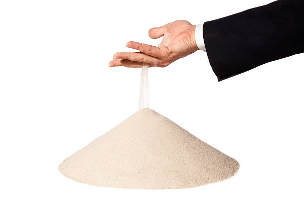 istock hand of businessman with falling sand on pile 528708663