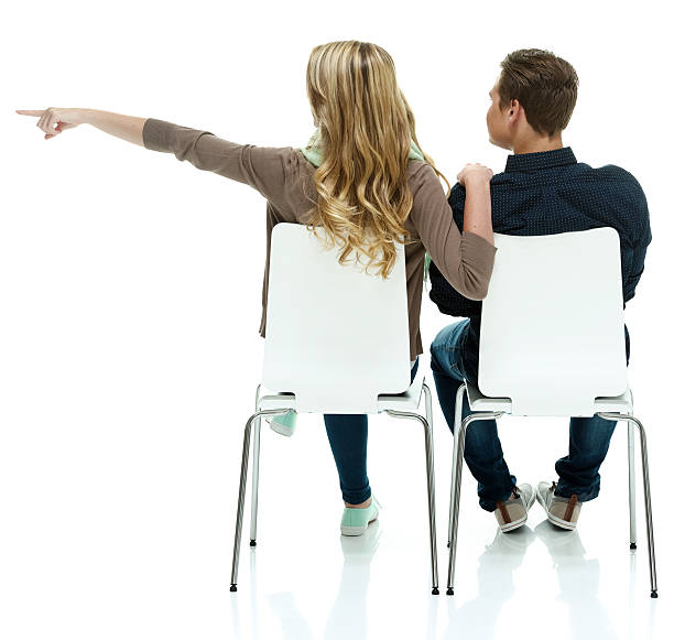 istock Couple sitting on chair & pointing away 528709155