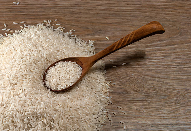 istock Rice pour on wood panels and a wooden spoon. 528714500