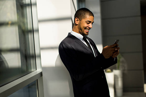istock Handsome young black man with mobile phone in the office 528716380
