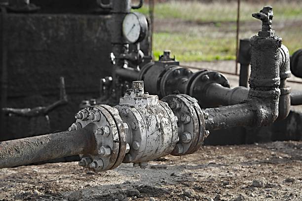 Oil Well Deatil Dirty pipe structure of an oil well oil pump incomplete rough oil stock pictures, royalty-free photos & images