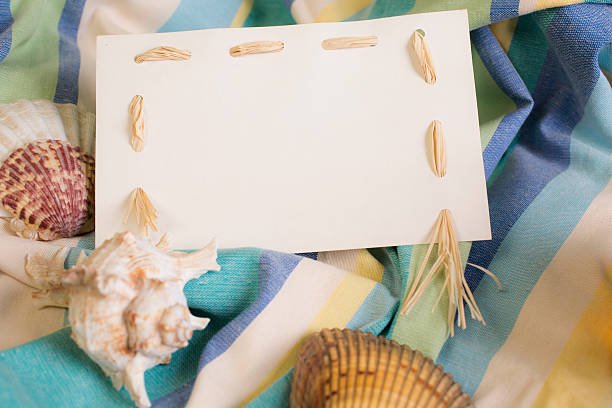istock Summer vacation.  Blank, white notecard with seashells, beach blanket. 528719618