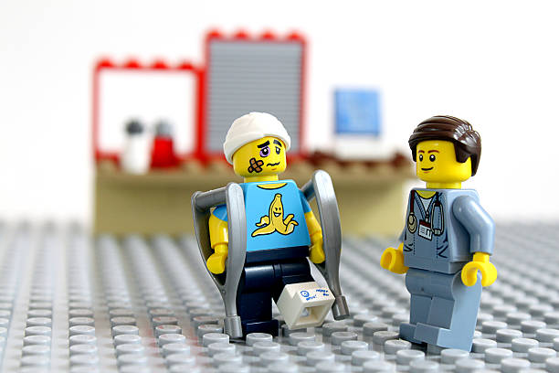 Injured and Doctor Colorado, USA - April 17, 2016: Studio shot of LEGO minifigure doctor and his injured patient. bruised fruit stock pictures, royalty-free photos & images