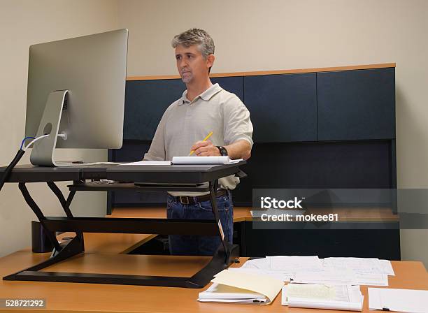 Man Using Stand Up Desk In Office For Good Health Stock Photo - Download Image Now - Standing Desk, Ergonomics, Office