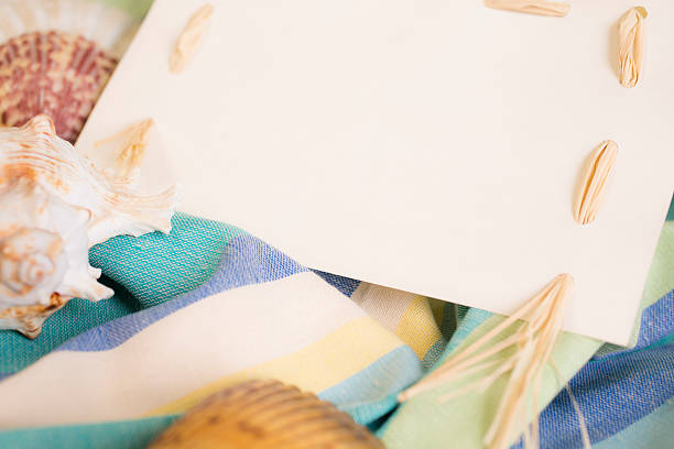 istock Summer vacation.  Blank, white notecard with seashells, beach blanket. 528724594