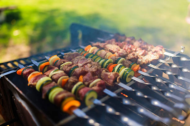 istock Meat and vegetable skewers on grill in nature 528725126
