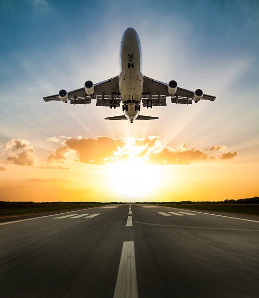 passagier-flugzeug abheben bei sonnenuntergang  - start und landebahn stock-fotos und bilder