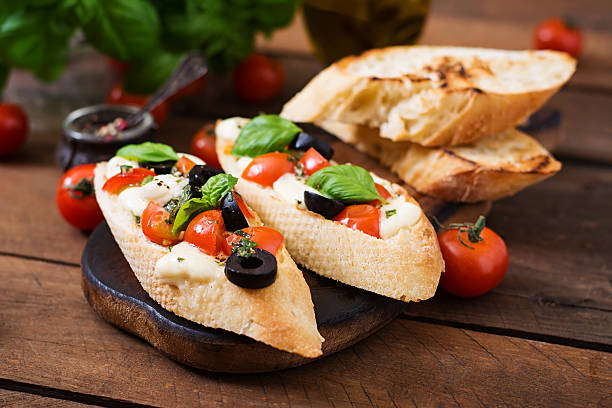 istock Bruschetta with tomatoes, mozzarella, olives and basil pesto 528728586