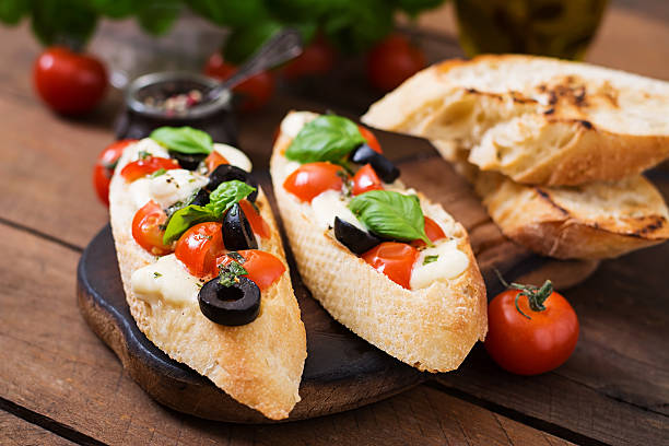 istock Bruschetta with tomatoes, mozzarella, olives and basil pesto 528728624