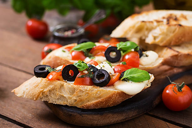 istock Bruschetta with tomatoes, mozzarella, olives and basil pesto 528728978