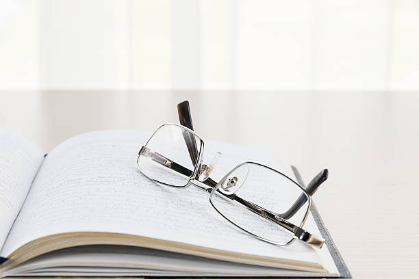 istock Eyeglasses put on a book with on the desk 528728998