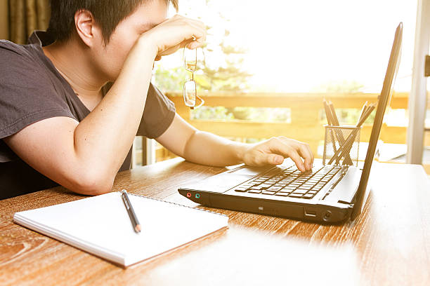 uomo stanco strofinarsi gli occhi mentre usando il computer portatile - human eye tired rubbing businessman foto e immagini stock