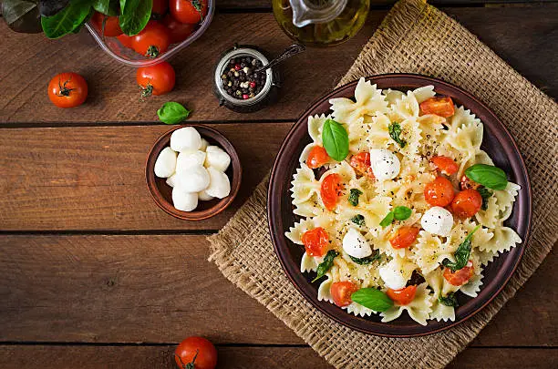 Farfalle Pasta - Caprese salad with tomato, mozzarella and basil. Top view