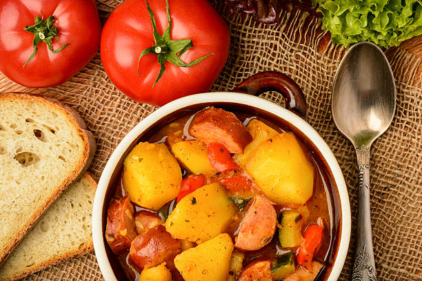 istock Vegetables stewed with pork sausages in ceramic pot. 528736890