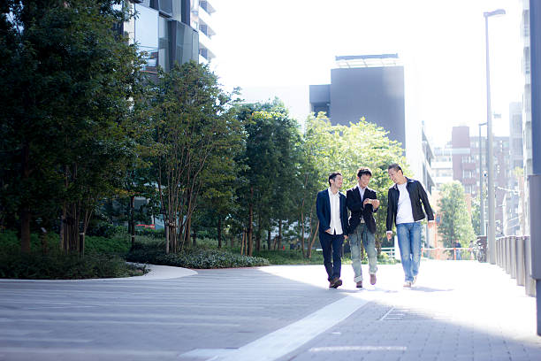 istock Three people walking on a sidewalk in a town 528737294