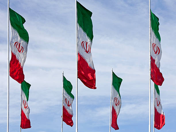 istock Waving Iranian Flags against Cloudy Blue Sky 528738583