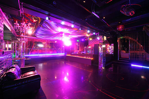 A fender from a 1950's American car, bathed in green and pink neon light.