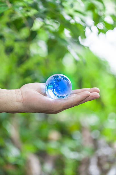 main tenir bleu cristal ballon - transparent crystal crystal ball human hand photos et images de collection