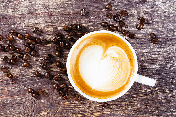 istock Cup of coffee and roasted bean on old wooden table 528742813