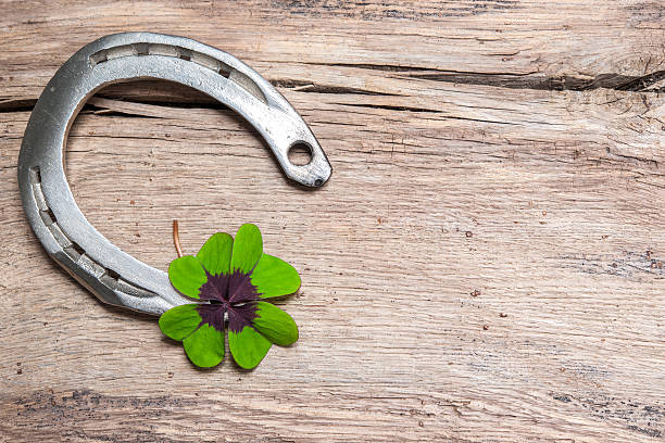 istock Horseshoe with a shamrock on old wooden 528743321