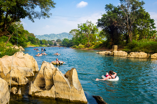 Vang Vieng, Laos - December 10, 2013: Tourists tubing down the Song River at Vang Vieng, Vientiane Province, Laos.