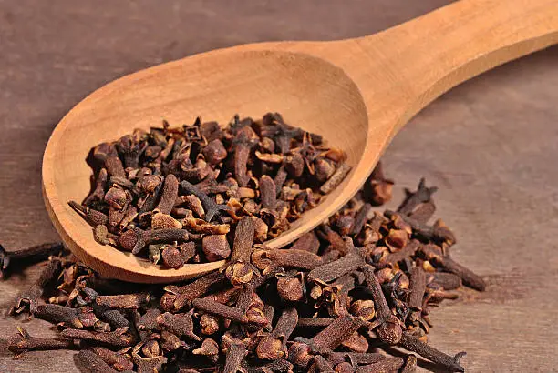 Dried clove in a wooden spoon