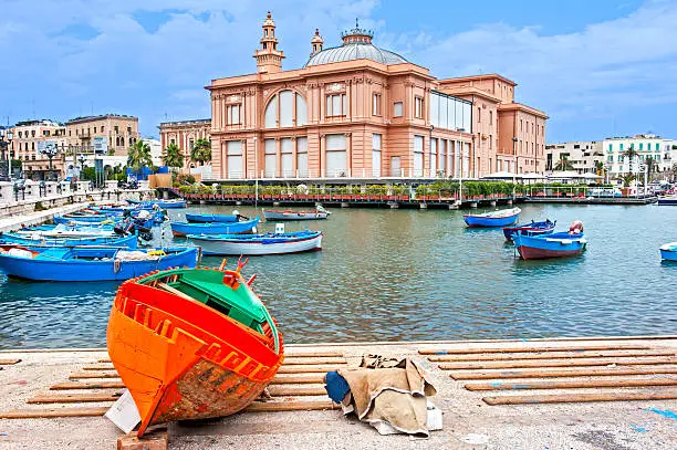 Bari port with traditional fishing boat and Margherita theare