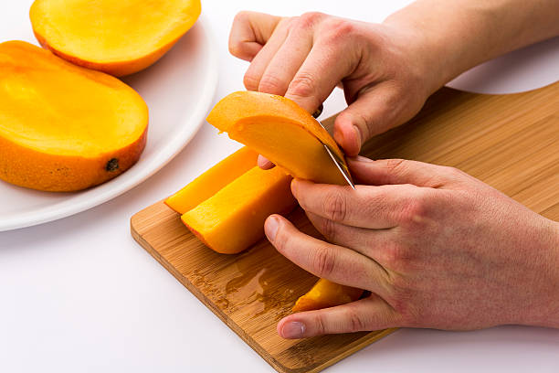istock Two Male Hands Peeling A Juicy Mango Fruit Chip 528767147