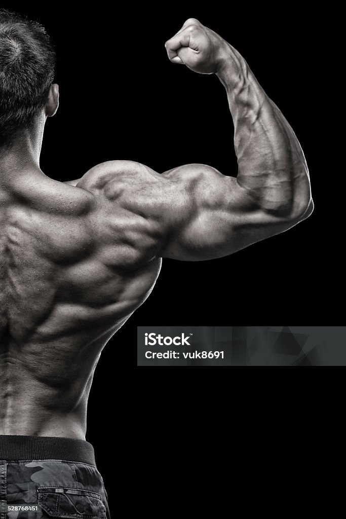 Big gun Body builder flexing biceps in front of black background 20-24 Years Stock Photo