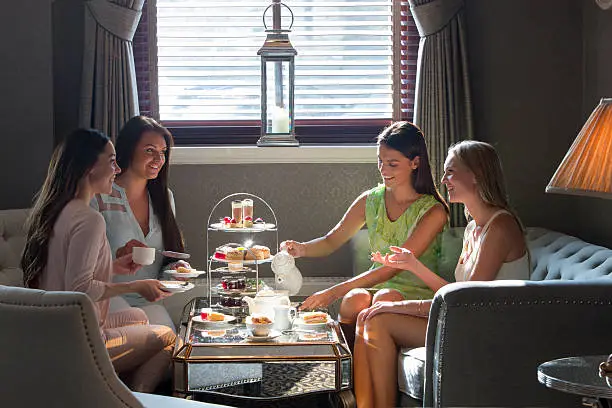 Women enjoy afternoon tea together and a catch up in a restaurant.