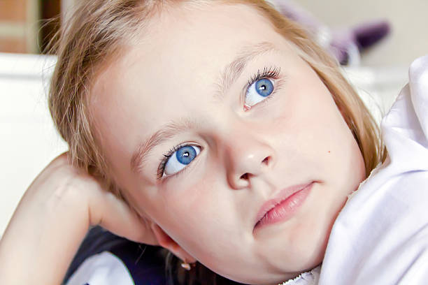 Smiling little girl with blue eyes in the village yard