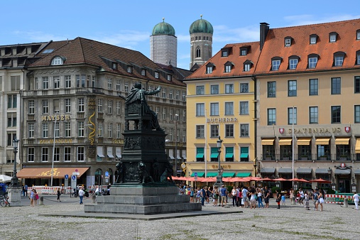Munich, Germany - August 10, 2014: Max-Joseph-Platz view, a large square in central Munich which was named after King Maximilian Joseph. It's the western starting point of the royal avenue Maximilianstraße and a popular sightseeing site in Munich. In the background people walking on the circle square