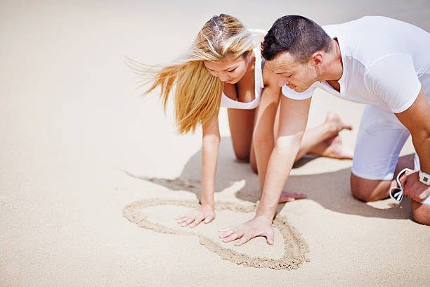 istock Couple drawing heart in the sand 528795777