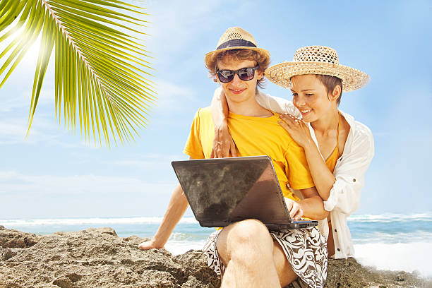 istock Happy couple with their laptop on the beach 528796545