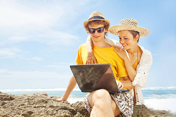 istock Happy couple with their laptop on the beach 528796643