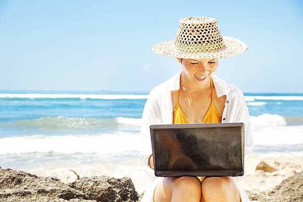 istock Young woman with her laptop on the beach 528796919