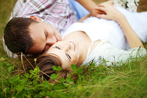 istock Husband hugging his pregnant wife lying on the grass 528815785